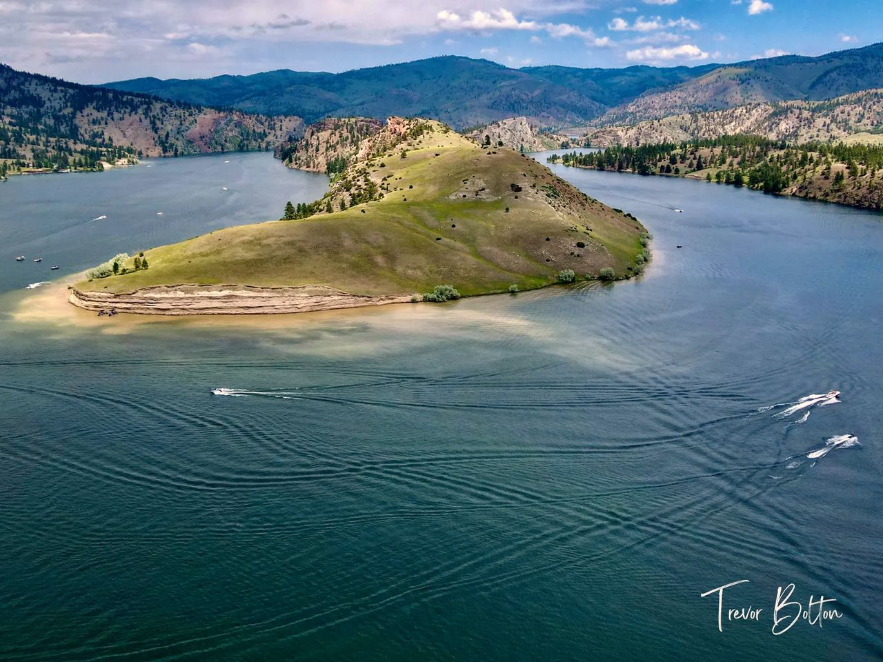 Boats around an island on a lake near Great Falls, drone photo by Trevor Bolton